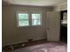 Shows a bedroom with damage to the hardwood floor, light walls, and two windows at 1769 S Nc 16 Hwy, Denver, NC 28037