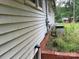Shows the side exterior elevation of a house with overgrown weeds and an air conditioning unit at 1769 S Nc 16 Hwy, Denver, NC 28037