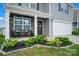 Inviting front porch with stone accents, a cozy seating area, and lush landscaping at 2013 Eastway Dr, Dallas, NC 28034