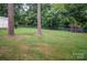 A large backyard space showcasing large trees and a well maintained grassy lawn at 2108 Twin Ave, Gastonia, NC 28052