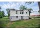 View of the rear of the home, showcasing the backyard, gray painted foundation and stairway access at 2108 Twin Ave, Gastonia, NC 28052
