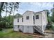 View of the rear exterior of the home showcasing access stairs and a spacious fenced backyard at 2108 Twin Ave, Gastonia, NC 28052