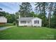 Quaint, single-story home with a lush green lawn, mature trees, and a clean, white exterior at 2108 Twin Ave, Gastonia, NC 28052