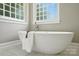 Bright bathroom features a soaking tub beneath two privacy windows at 21621 Crown Lake Dr, Cornelius, NC 28031