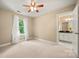 Bright bedroom featuring neutral walls, ceiling fan, and adjacent bathroom entrance at 21621 Crown Lake Dr, Cornelius, NC 28031