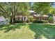 Stately brick home with a lush, green lawn and mature trees providing shade at 21621 Crown Lake Dr, Cornelius, NC 28031