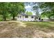Charming renovated home with white brick exterior, black accents, and mature trees at 2280 Cannon Farm Rd, China Grove, NC 28023