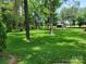 A backyard with lush, green grass and mature trees, featuring a storage shed at 2777 Old South Nw Ct, Concord, NC 28027