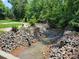 Picturesque creek surrounded by natural rock features and lush greenery at 2777 Old South Nw Ct, Concord, NC 28027