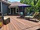 Relaxing deck area with dining table, lounge chairs and sun umbrella overlooking the backyard at 2777 Old South Nw Ct, Concord, NC 28027