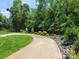 Long driveway leading to property, edged with lush landscaping and mature trees, creating an inviting entrance at 2777 Old South Nw Ct, Concord, NC 28027