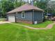 Exterior view of the home shows the attached garage, brick foundation, and well maintained lawn at 2777 Old South Nw Ct, Concord, NC 28027