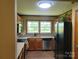 Kitchen view highlighting stainless steel appliances, wood cabinets, and double windows at 2777 Old South Nw Ct, Concord, NC 28027