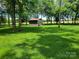 A detached storage shed set among mature trees in the expansive backyard at 2777 Old South Nw Ct, Concord, NC 28027