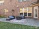 Brick home featuring a backyard stone patio with outdoor furniture, a fireplace and green grass at 2785 Disney Pl, Indian Land, SC 29707