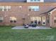 Brick home featuring a backyard stone patio with outdoor furniture, a fireplace and green grass at 2785 Disney Pl, Indian Land, SC 29707