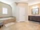 Bright bathroom features a soaking tub, a vanity with dark cabinets, and tile flooring at 2785 Disney Pl, Indian Land, SC 29707