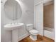 Bathroom with a pedestal sink, toilet, and tiled shower/tub, complemented by modern fixtures and hardwood floors at 2785 Disney Pl, Indian Land, SC 29707