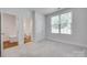 A clean bedroom with a large window, carpet, and a closet near the bathroom at 2785 Disney Pl, Indian Land, SC 29707