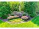Landscaped community entrance with a brick sign, vibrant flowers, and manicured lawn at 2785 Disney Pl, Indian Land, SC 29707