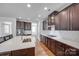 Bright kitchen with dark cabinets, white backsplash and countertops, stainless steel appliances, and hardwood floors at 2785 Disney Pl, Indian Land, SC 29707