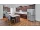 A modern kitchen featuring dark cabinets, a stainless steel refrigerator, and a center island with bar seating at 2785 Disney Pl, Indian Land, SC 29707