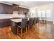 Kitchen with an island and barstool seating, dark wood cabinets, stainless steel appliances and hardwood floors at 2785 Disney Pl, Indian Land, SC 29707