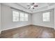 Bright main bedroom with hardwood floors, ceiling fan, tray ceiling, and large windows at 2785 Disney Pl, Indian Land, SC 29707