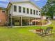 Backyard patio area with a fire pit, seating, and spiral staircase to a multi-story home above at 310 Yarbro Rd, Kings Mountain, NC 28086