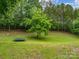 A beautiful backyard with a trampoline, a large tree, and lush green grass at 310 Yarbro Rd, Kings Mountain, NC 28086