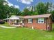 Charming brick home featuring a covered front porch, spacious lawn, and mature trees at 310 Yarbro Rd, Kings Mountain, NC 28086