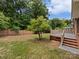 Spacious backyard with a patio, tree, brick wall, and lush greenery, perfect for outdoor entertaining at 3104 Doncaster Dr, Rock Hill, SC 29732