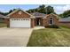 Welcoming brick home with lush green lawn, attached garage, and charming architectural details at 3104 Doncaster Dr, Rock Hill, SC 29732