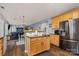 Kitchen with wood cabinets, an island, and stainless steel refrigerator open to living room at 3236 Wicklow Ln, Clover, SC 29710