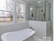Bathroom featuring a modern soaking tub, glass shower and large window at 332 Canvasback Rd, Mooresville, NC 28117