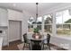 Cozy breakfast nook with a round table, black chairs, and windows overlooking the backyard at 332 Canvasback Rd, Mooresville, NC 28117