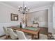 Dining room with wainscoting, a modern chandelier, and an elegant wood table at 332 Canvasback Rd, Mooresville, NC 28117