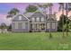 Charming two-story home with a large front lawn, blue siding, white trim, and a welcoming front porch at 332 Canvasback Rd, Mooresville, NC 28117