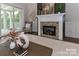 Living room fireplace with brick surround, white mantle, and sliding glass doors to a screened porch at 332 Canvasback Rd, Mooresville, NC 28117