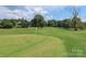 Scenic golf course view with a yellow flag, manicured green, and blue skies at 332 Canvasback Rd, Mooresville, NC 28117
