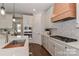 Modern kitchen with white cabinets, a wood range hood, and stainless steel appliances at 332 Canvasback Rd, Mooresville, NC 28117