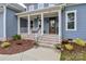 Inviting front porch with brick steps, white railing, seating, and a wood front door at 332 Canvasback Rd, Mooresville, NC 28117