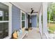 Cozy front porch with a ceiling fan, wood door, seating with decorative pillows and plants at 332 Canvasback Rd, Mooresville, NC 28117