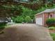 Long driveway leading to a two-car garage with an adjacent brick home, and green foliage at 3367 Tanglewood Dr, Rock Hill, SC 29732
