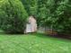 Backyard with a storage shed surrounded by green foliage, and manicured grass at 3367 Tanglewood Dr, Rock Hill, SC 29732