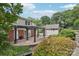 A lovely backyard featuring a brick patio with pergola, lush landscaping, and a storage building at 3916 Blowing Rock Way, Charlotte, NC 28210