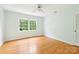 Bright bedroom with hardwood floors, a ceiling fan, and a large window offering ample natural light at 3916 Blowing Rock Way, Charlotte, NC 28210