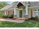 Inviting front entrance featuring brick accents, a green door, and a well-maintained landscaped walkway at 3916 Blowing Rock Way, Charlotte, NC 28210
