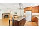 Open concept kitchen with island cooktop, stainless vent, and fireplace in the living room at 3916 Blowing Rock Way, Charlotte, NC 28210