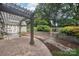 A beautiful backyard patio featuring a wooden pergola, stone retaining walls, and lush landscaping at 3916 Blowing Rock Way, Charlotte, NC 28210